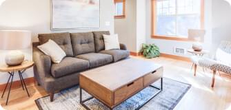 a living room with a couch, a table and two lamps on endtables