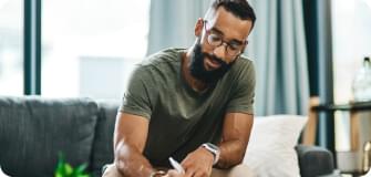 a man sitting on a couch signing something